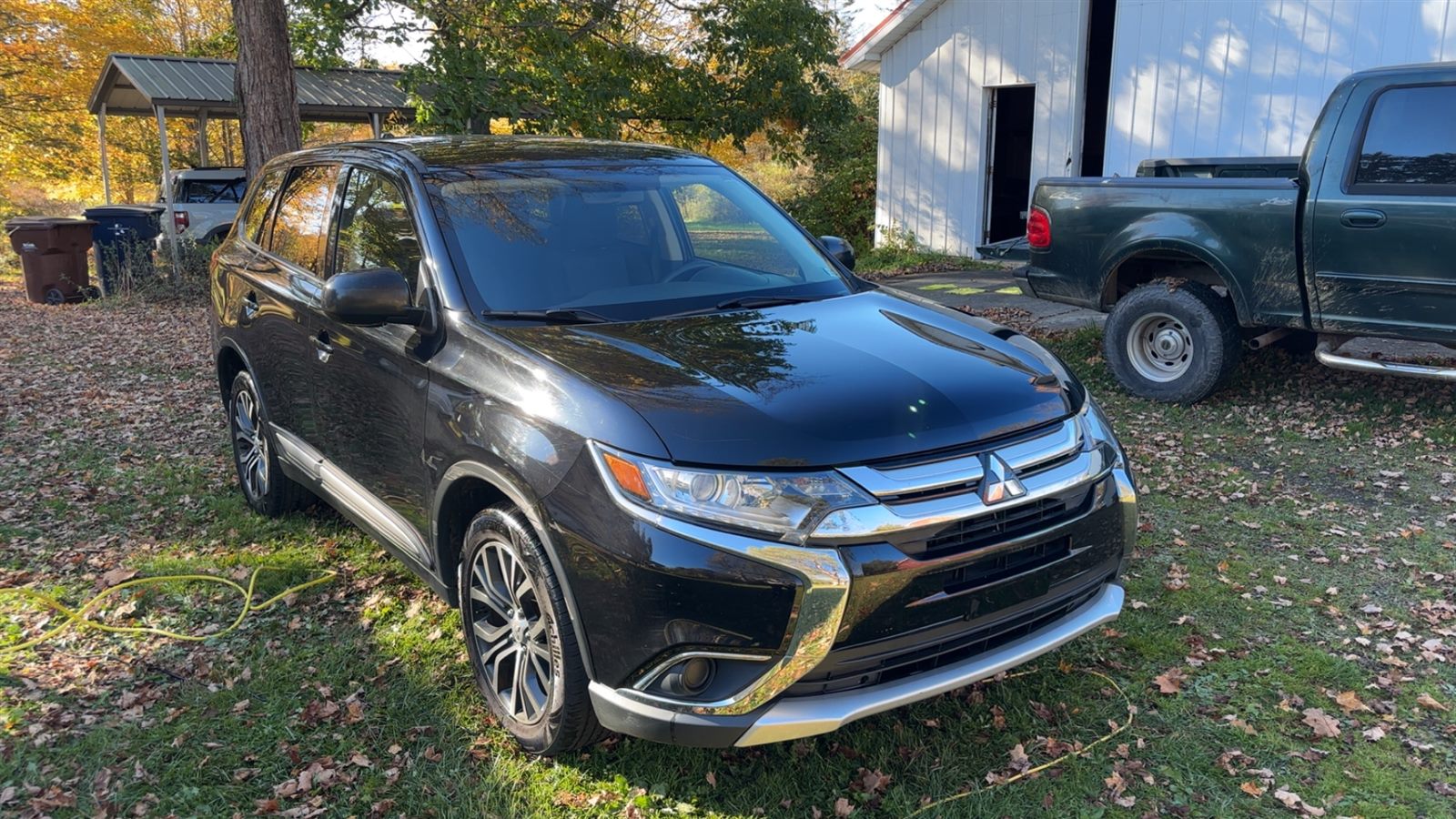 Freshly detailed black Mitsubishi Outlander in a driveway